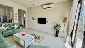 赫尔格达Luxury 3BR Townhouse, Tawila, El Gouna, Lagoon & Pool access的客厅配有沙发和墙上的电视