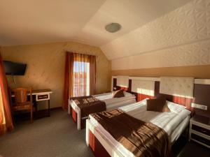 DragashMeka Hotel的酒店客房设有两张床和电视。