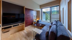 京都Fufu Kyoto的客厅配有蓝色的沙发和平面电视。