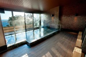 热海Atami Sekaie的大型游泳池,位于带大窗户的房间内