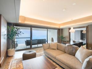 热海Atami Sekaie的带沙发的客厅,享有海景