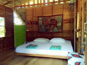 象岛Happy Hippy House2的墙上挂着照片的房间的一张秋千床