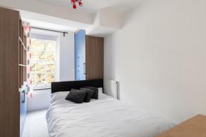 伦敦Flat near Lord's Cricket Ground的一间卧室配有一张带白色床单的床和一扇窗户。