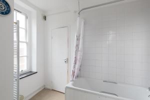 伦敦Flat near Lord's Cricket Ground的白色的浴室设有浴缸和窗户。