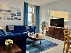 阿可贺巴Mandarin的客厅配有蓝色的沙发和电视