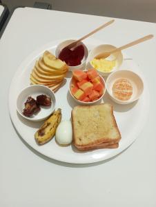 焦尔哈德Assam Villa - by Storyweavers Retreat的包括鸡蛋水果和烤面包的早餐盘