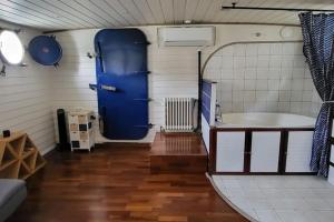 里昂Appartement dans Péniche atypique et idyllique à Confluence的浴室设有蓝色门和浴缸。
