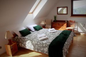 SzlembarkChatka Bernadka - w sercu Gorców的一间卧室配有一张带绿色和白色床单的床