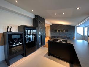 罗丁Luxus Loft über den Dächern von Roding的厨房配有黑色冰箱和台面