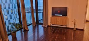 不来梅港Homey Apartments Harbor Suite - Parking Two Bathrooms Netflix Sea view的一间带电视和大窗户的客厅