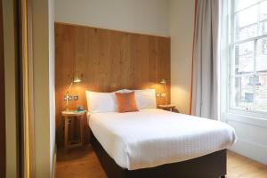 爱丁堡Cairn Hotel & Apartments的一间卧室设有一张大床和窗户