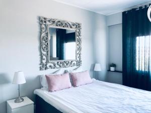 波里Kotimaailma Pori City的卧室配有大镜子,位于床上方
