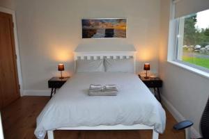 福克斯福德Twin Lake View - Bungalow in Pontoon的一间卧室配有一张带两盏灯的大型白色床。