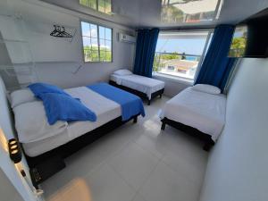 圣安德烈斯Apartamentos Chalet del Mar的一间小卧室,配有两张床和窗户