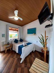 阿布拉奥Suites Casa Azul-Vila do Abraão- conforto, limpeza, ótima localização的一间卧室配有一张床和吊扇