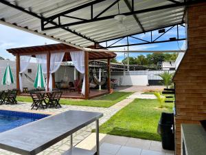 新艾朗Casa Boto Tucuxi 2的一个带遮阳篷、桌子和游泳池的庭院