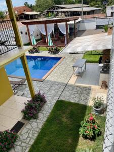 新艾朗Casa Boto Tucuxi 2的一个带游泳池、桌子和鲜花的庭院