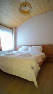 巴库里阿尼Zarku Apartments的卧室设有一张白色大床和一扇窗户。