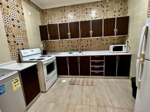 阿可贺巴Mandarin的厨房配有棕色橱柜和白色用具