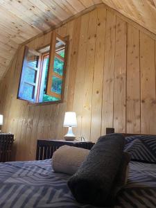 普利特维采湖Wooden house with a waterfall "Stipanov mlin"的一间卧室设有木墙和一张带窗户的床