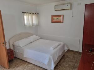 尼夫佐哈Loren Village的一间卧室配有一张带白色床单的床和一扇窗户。