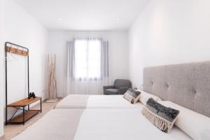 加拉奇科Garachico Homes - LA CASA DE VICTORIA的白色卧室配有一张大床和椅子