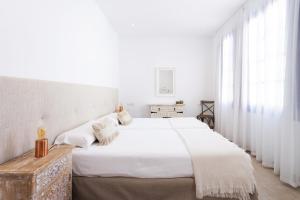 加拉奇科Garachico Homes - LA CASA DE VICTORIA的一间白色卧室,配有两张床和窗户