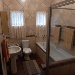 姆通济尼Rilli's Inn Apartment的浴室配有卫生间、浴缸和水槽。