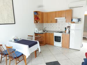 马林斯卡Vila Kraljica的厨房配有白色冰箱、桌子和椅子