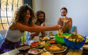 达哈布Rafiki Hostels - Dahab的一群人坐在桌子旁吃着食物