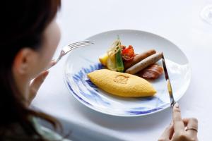 轻井泽王子轻井泽酒店的坐在餐桌上吃一盘食物的女人