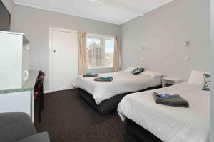 纳鲁马绿树汽车旅馆的酒店客房设有两张床和窗户。