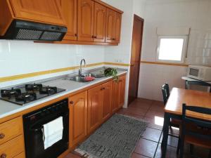 BeniarbeigAcogedora casa de pueblo en Beniarbeig - Alicante Alma的厨房配有木制橱柜、水槽和炉灶。