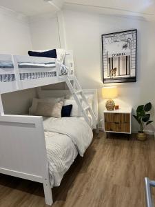 斯卡伯勒Comfortable Beach Home Scarborough的卧室配有白色双层床和书桌