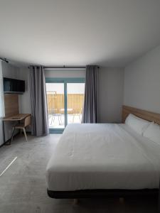 阿拉萨特-蒙德拉贡Casa rural Goiko Errota landetxea的一间带一张白色大床的卧室和一个阳台