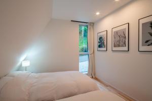 轻井泽A-Frame House Minami Karuizawa - Vacation STAY 58046v的白色的卧室设有床和窗户