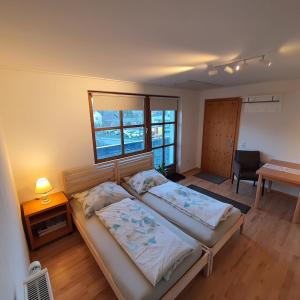 嫩青Apartments ChezTom Nenzing的一间卧室配有两张床、一张桌子和一张书桌