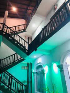 乌纳瓦图纳Hiru Resort Inn Unawatuna的绿色灯光的建筑里的一个楼梯