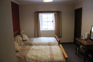 克雷格纽尔Craignure Inn的一间卧室设有两张床和窗户。