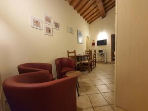 圣吉米纳诺Appartamenti Tinacci的一间设有红色椅子和桌子的等候室