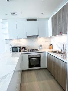 迪拜STAY Sensational 3BR Holiday Home near BurjKhalifa的白色的厨房配有白色的橱柜和微波炉