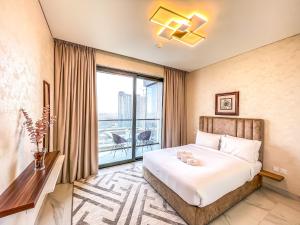 迪拜STAY Sensational 3BR Holiday Home near BurjKhalifa的酒店客房设有一张床和一个大窗户