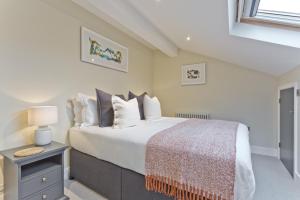 彭里斯Sandgate Chapel - Self Check In Apartments的卧室配有一张带白色床单和枕头的大床。