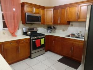 Tortola IslandAbigail's Sunflower Entire 2 Bedroom Apt的厨房配有木制橱柜和炉灶烤箱。