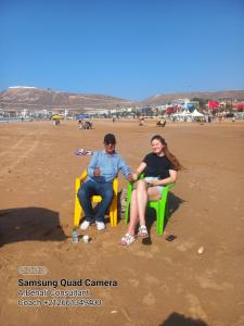 阿加迪尔Chambre chez l'habitant avec famille的坐在海滩长凳上的男人和女人