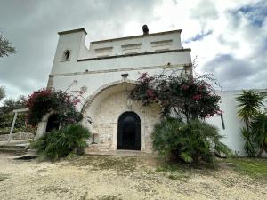 维耶斯泰Villa del 1700 immersa nel verde, Poggio al Sole Vieste的一座小建筑,前面有鲜花