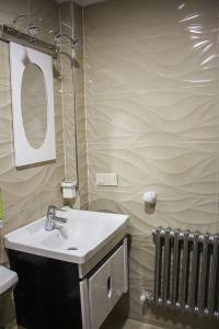 伊夫兰APPARTEMENT AMIRA iFRANE的一间带水槽、镜子和散热器的浴室