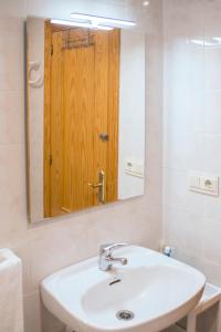 拉拉维塔El Cachalote Feliz的一间带水槽和镜子的浴室,配有木门