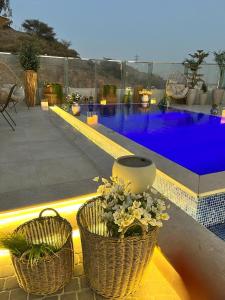 塔伊夫Sudfa Hotel的庭院里一座游泳池,两篮鲜花
