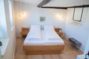富尔达河畔罗滕堡BACCO Bed & Breakfast的一间卧室配有一张带白色床单的大床